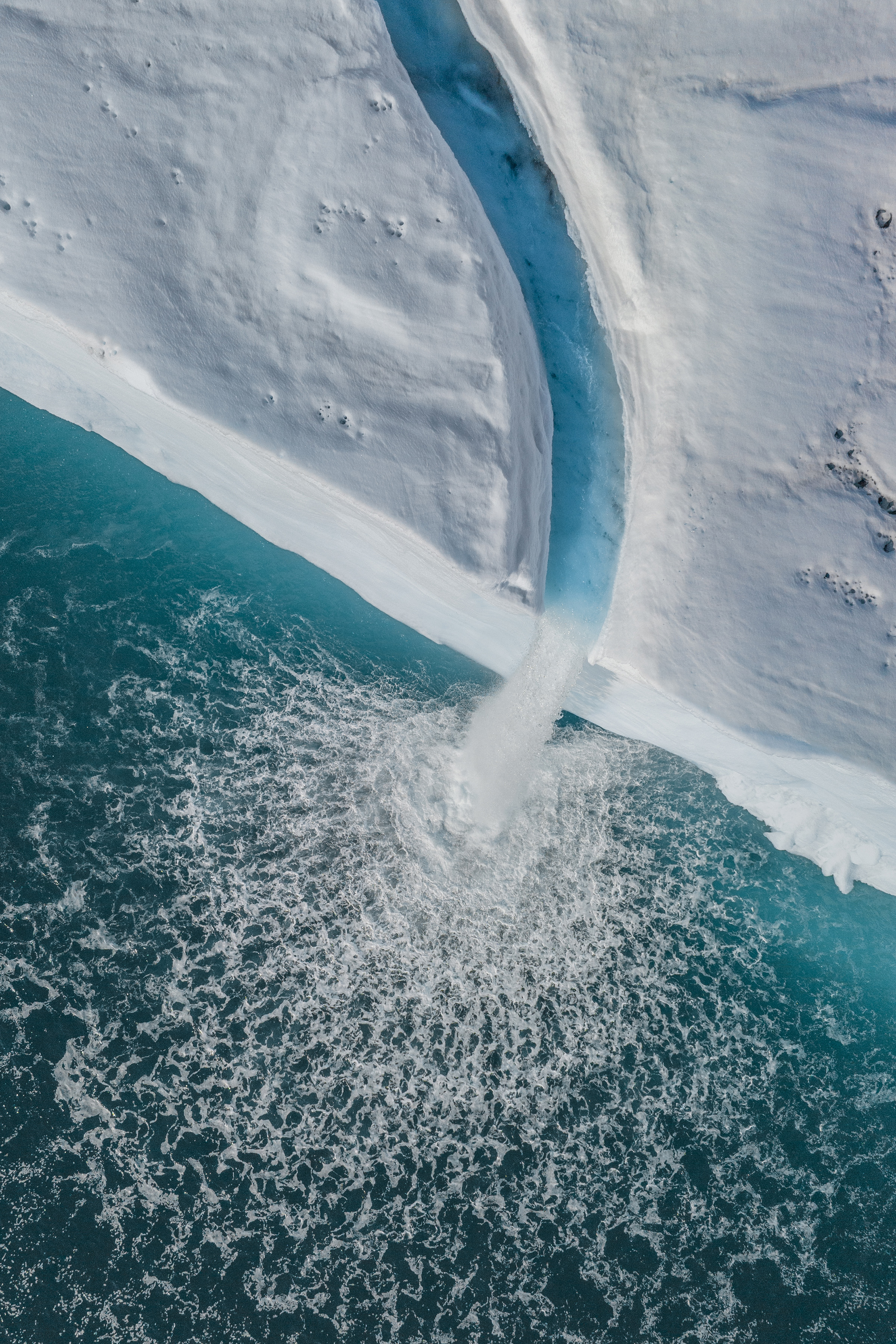 The iceshelf extends for hundreds of kilometres along the high arctic landscape. The jagged perfectly sculptured edges show the sheer magnitude of ice protruding into the ocean. 