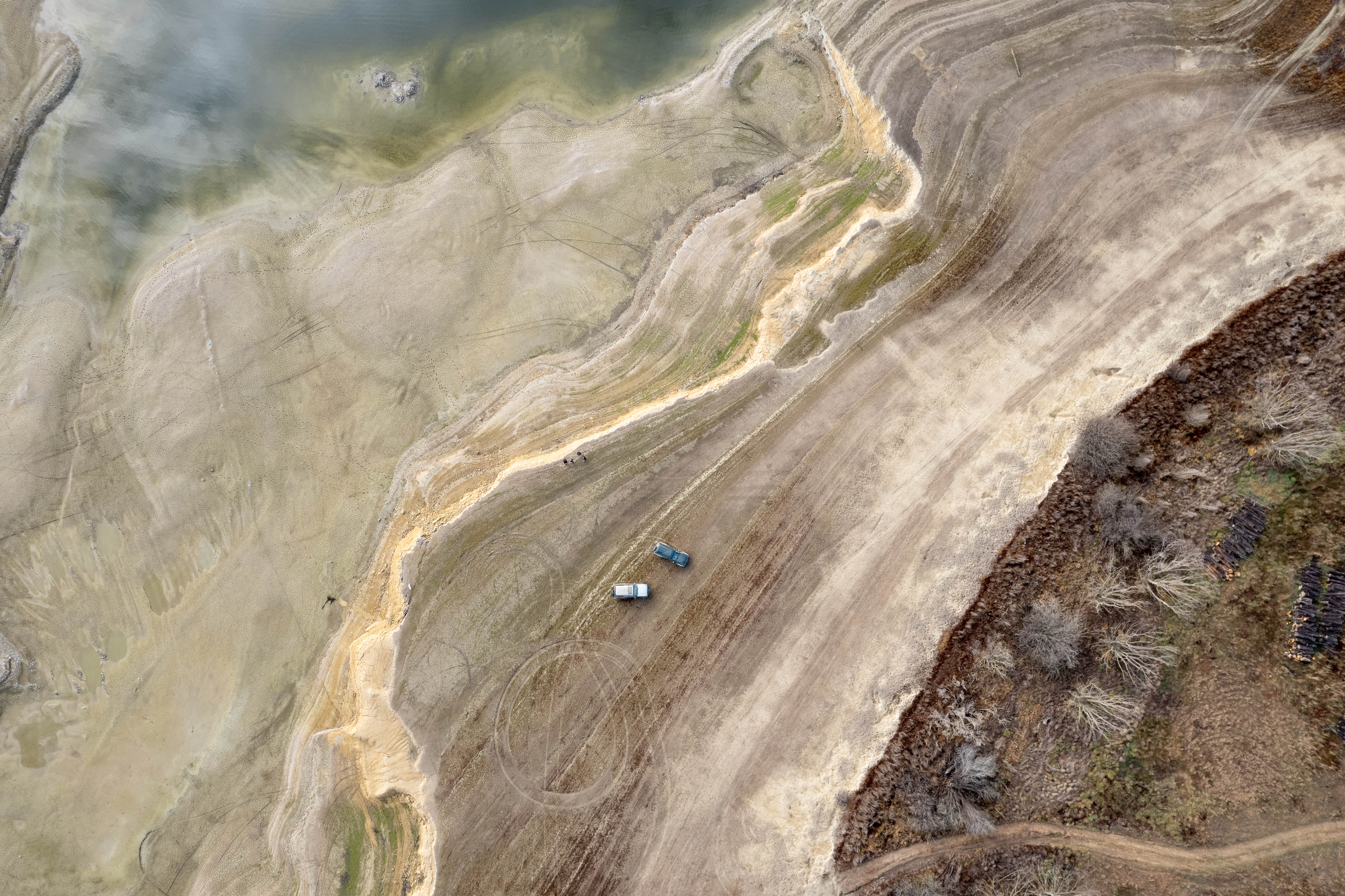 An aerial image of a lake suffering from the drought, no water, just brown and beige land and lines showing where the water used to be